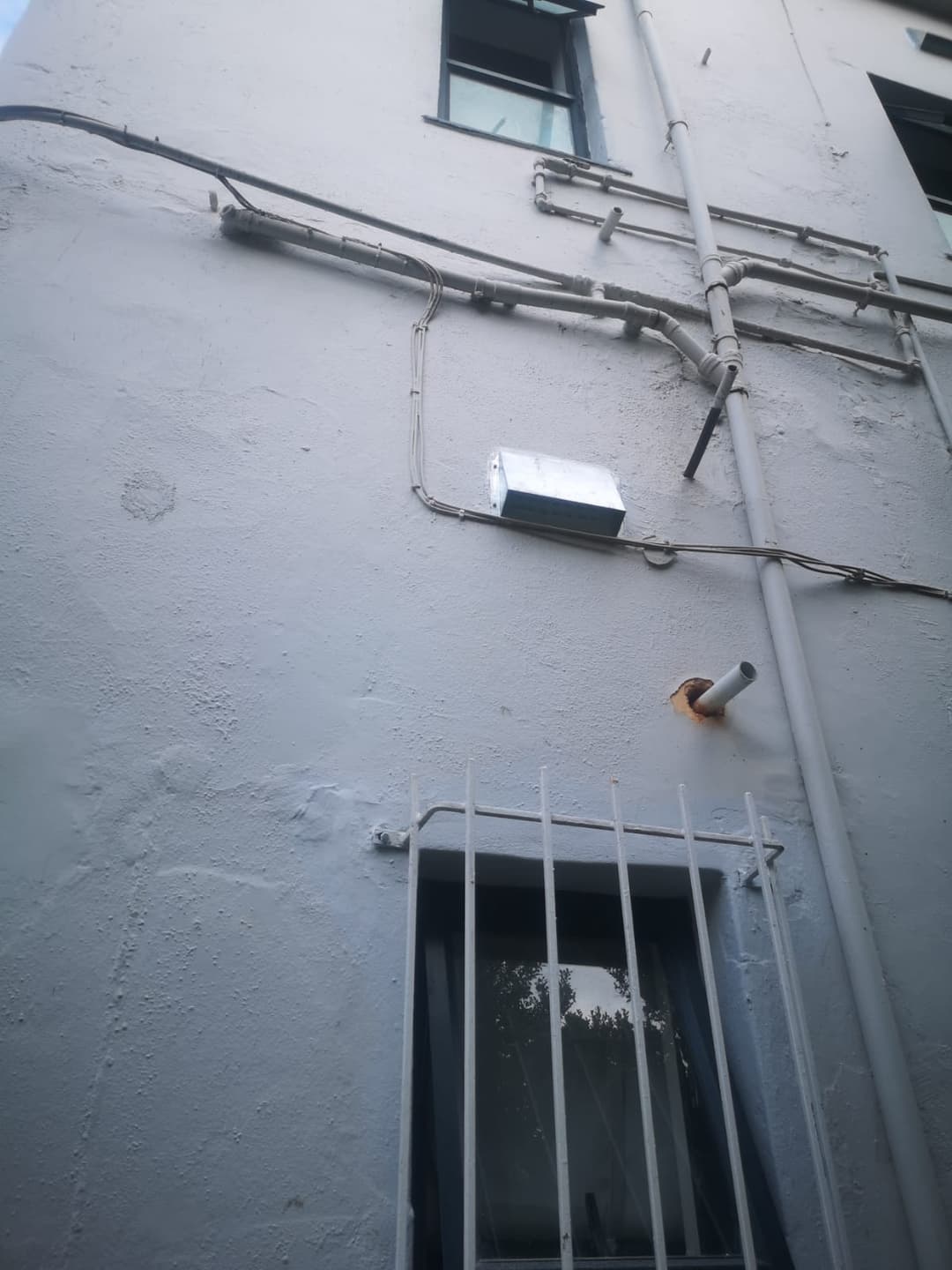 Close-up of a galvanised vent cover on a wall