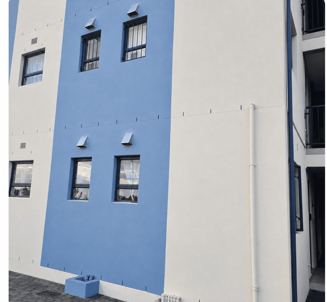 Vent covers installed on the walls of a painted apartment building